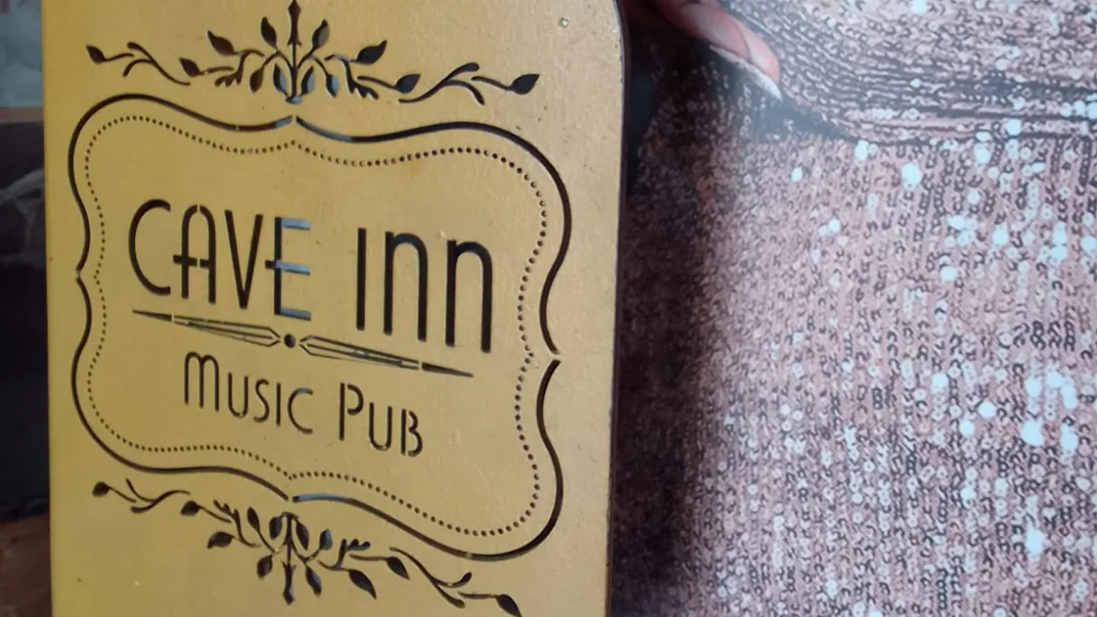 Logotipo en relieve de Cave Inn Music Pub impreso en metal